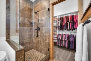 Full bath featuring a stall shower and a walk in closet
