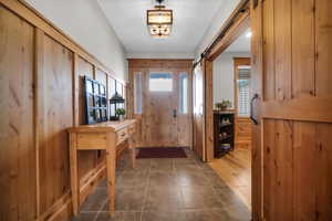 Entrance foyer featuring dark tile patterned flooring and a barn door