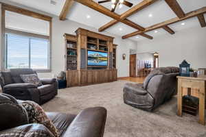 Living area featuring ceiling fan, beam ceiling, carpet, recessed lighting, and coffered ceiling