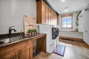 Laundry room with washing machine and dryer, cabinet space, recessed lighting, and light tile patterned floors