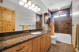 Full bath with vanity, shower / bath combination with curtain, and tile patterned flooring