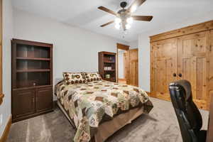 Carpeted bedroom featuring baseboards and a ceiling fan