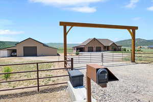View of yard featuring a garage, an outdoor structure, a mountain view, a pole building, and a view of countryside