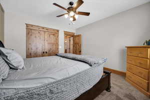 Bedroom with light colored carpet and a ceiling fan