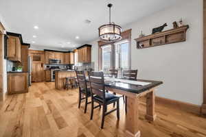 Dining room with light wood-style flooring, recessed lighting, and a chandelier