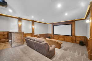 Carpeted home theater room with a wainscoted wall and recessed lighting