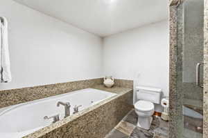 Full bath with a tub with jets and a stall shower