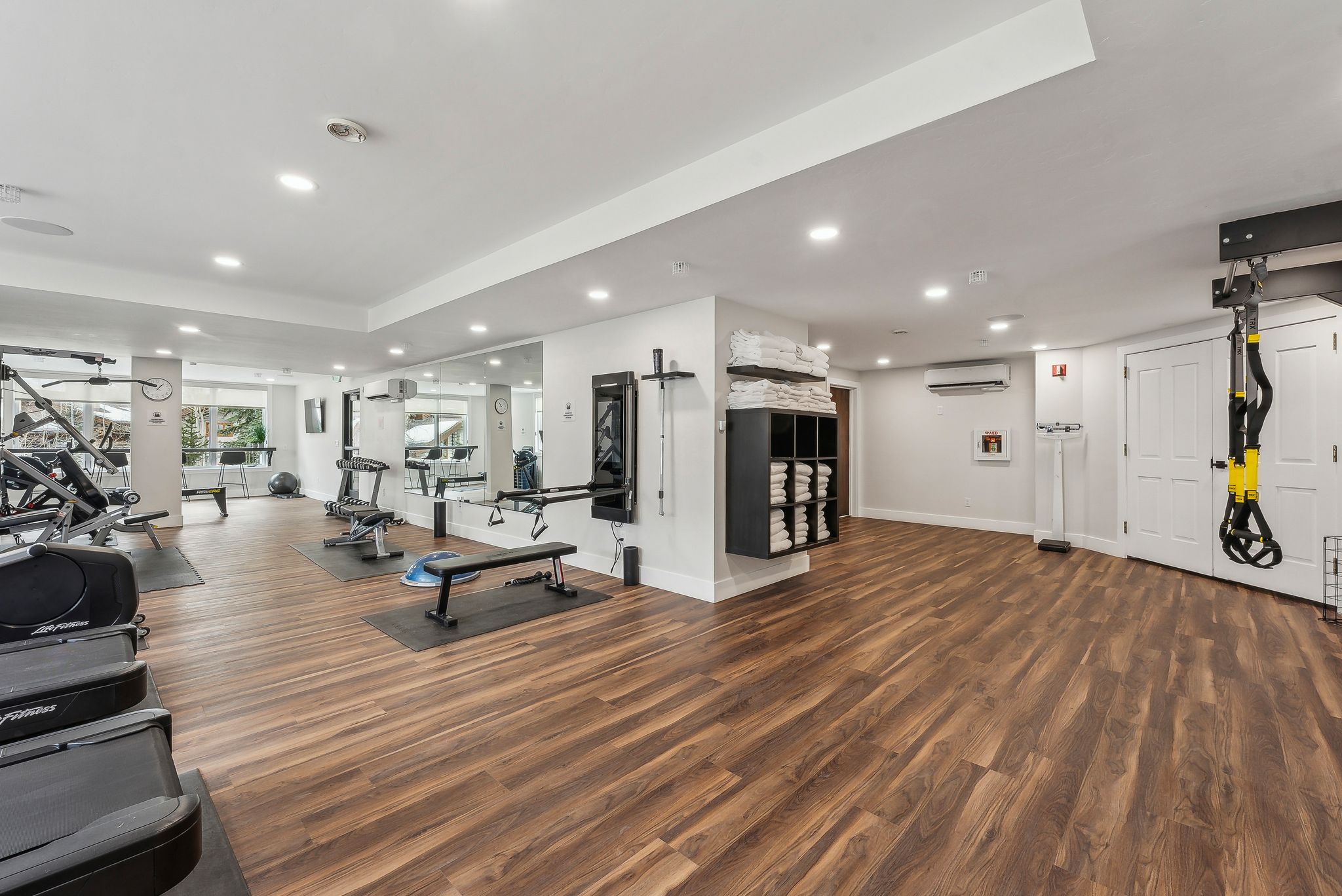 Workout area featuring a wall unit AC, recessed lighting, wood finished floors, and baseboards