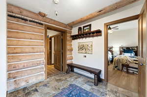 Corridor featuring stone tile flooring and log walls