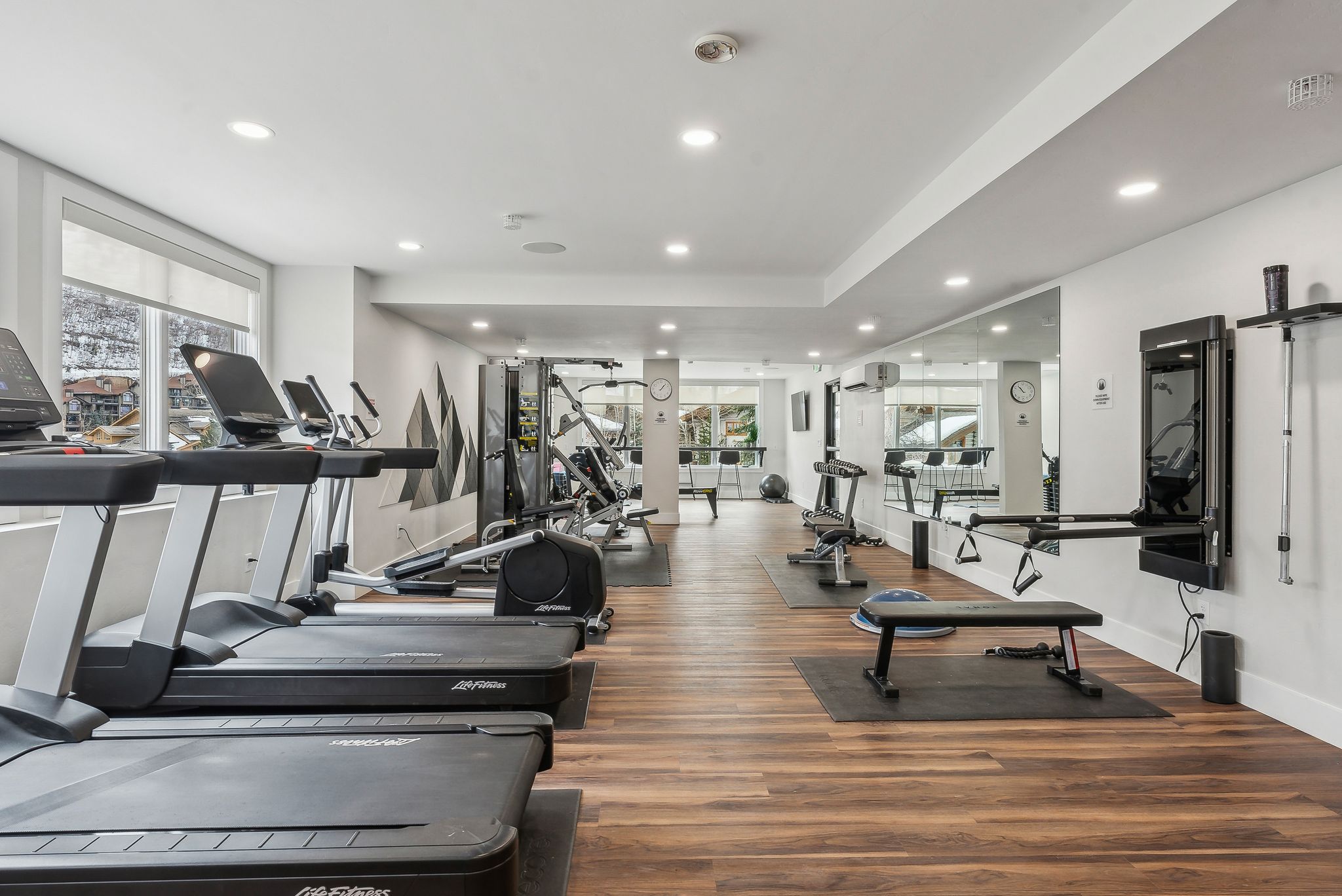 Workout area featuring recessed lighting, an AC wall unit, baseboards, and wood finished floors