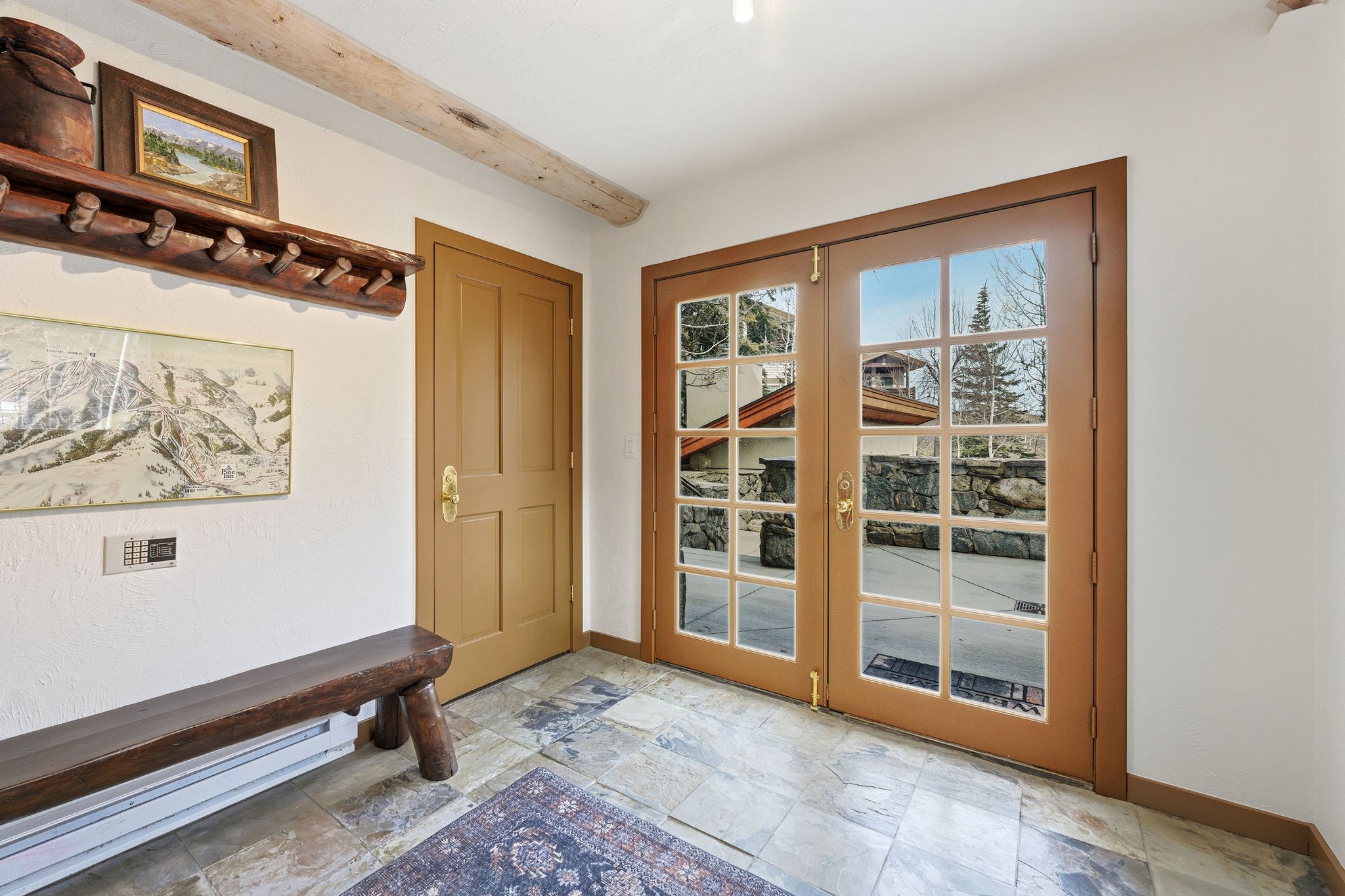 Entryway with french doors, a baseboard radiator, stone tile flooring, and beam ceiling