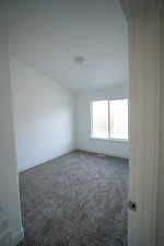 Carpeted spare room with baseboards