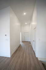 Hall with recessed lighting, visible vents, baseboards, and dark wood-style floors