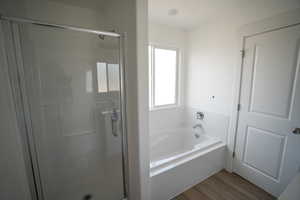 Full bath with a garden tub, wood finished floors, and a shower stall
