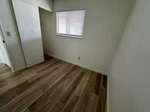 Unfurnished bedroom with baseboards and wood finished floors