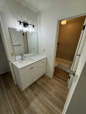 Bathroom featuring vanity, toilet, wood finished floors, and baseboards