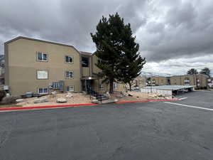 View of building exterior featuring uncovered parking