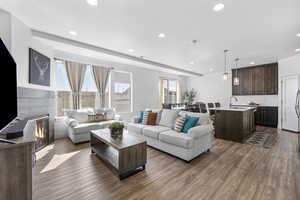 Living room with recessed lighting, a fireplace, and dark wood-style flooring