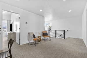Living area with baseboards, recessed lighting, a textured ceiling, carpet flooring, and an upstairs landing