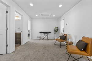 Living area with attic access, carpet flooring, recessed lighting, and baseboards