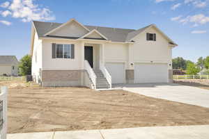 View of front of home featuring brick siding, a garage, driveway, and a shingled roof