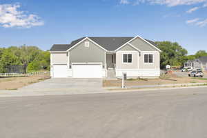 View of front of property featuring concrete driveway and an attached garage