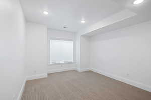 Unfurnished room with visible vents, recessed lighting, baseboards, and carpet
