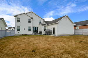 Back of property featuring a gate, a patio area, a lawn, and fence