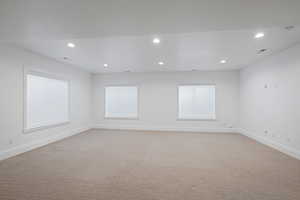 Empty room featuring light carpet, visible vents, recessed lighting, and baseboards