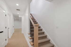 Stairway with visible vents, recessed lighting, carpet flooring, and baseboards