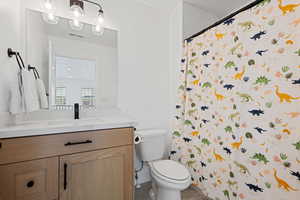 Bathroom featuring visible vents, toilet, vanity, and a shower with shower curtain