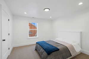 Carpeted bedroom with recessed lighting, visible vents, and baseboards
