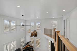 Corridor featuring recessed lighting, a healthy amount of sunlight, and baseboards