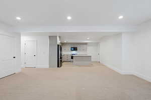 Unfurnished living room featuring recessed lighting, baseboards, and light colored carpet