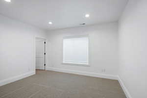 Unfurnished room with recessed lighting, visible vents, baseboards, and carpet floors