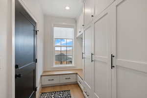 Mudroom featuring recessed lighting, light wood-style floors, and baseboards