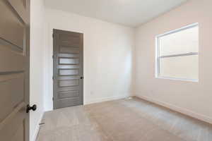 Carpeted empty room featuring baseboards