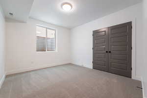 Unfurnished bedroom with visible vents, baseboards, carpet floors, a closet, and a textured ceiling