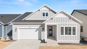 Modern farmhouse with driveway, an attached garage, board and batten siding, and roof with shingles