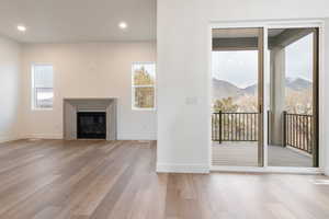 Unfurnished living room featuring wood finished floors, visible vents, a mountain view, and baseboards