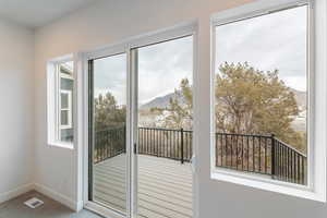 Doorway with visible vents, a healthy amount of sunlight, a mountain view, and baseboards