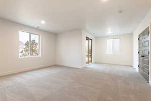 Unfurnished room with recessed lighting, light colored carpet, visible vents, and baseboards