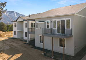 Exterior space with stucco siding, a mountain view, and a balcony