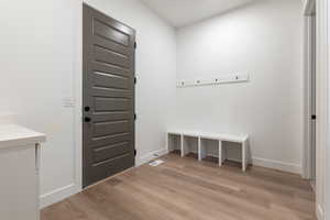 Mudroom featuring baseboards and light wood-style floors