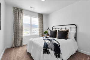 Carpeted bedroom with a mountain view, baseboards, and visible vents