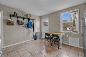 Dining area featuring light tile patterned flooring, baseboards, and visible vents