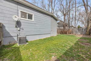 View of yard featuring central AC and fence