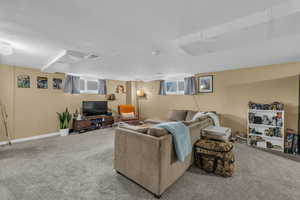 Living room with visible vents, carpet flooring, a textured ceiling, and baseboards