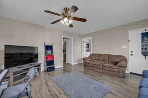 Living area with wood finished floors, baseboards, and ceiling fan