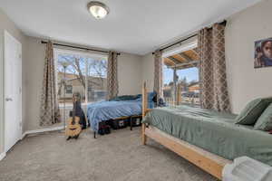 Carpeted bedroom featuring multiple windows and baseboards